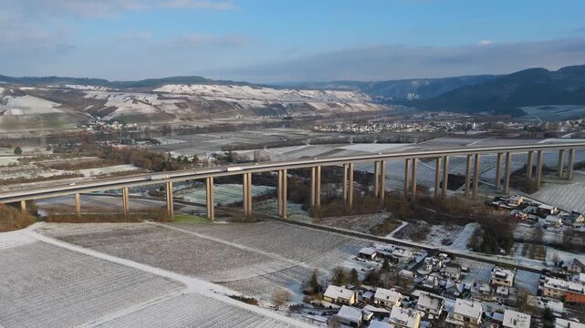 Moselle vineyard, Viaduct Longuich, Mosel valley, snow in winter season, bridge of highway crossing river near Trier, aerial view