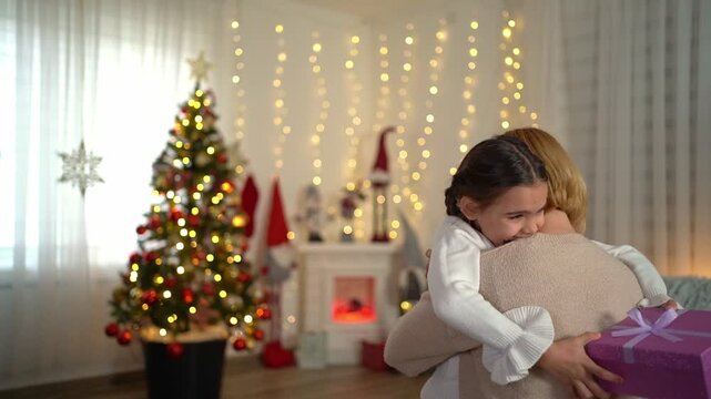 Little girl hugging her mother on christmas morning
