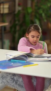 Tired schoolgirl completing homework at home