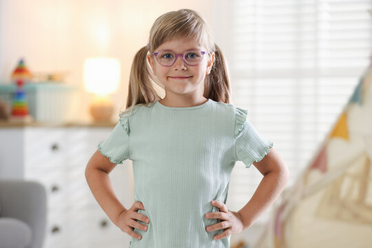 Portrait of cute little girl in glasses at home