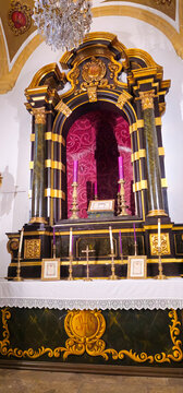 Ornate church altar with gilded decoration, candles and devotional objects inside Iglesia Parroquial de San Pablo, Baeza, Andalusia, Spain.