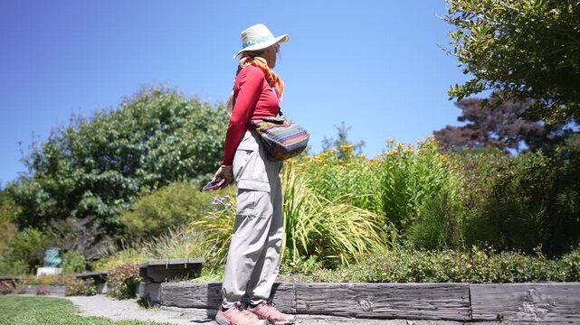 Mature woman walks through Mendocino coast Botanical Gardens in Fort Bragg.
