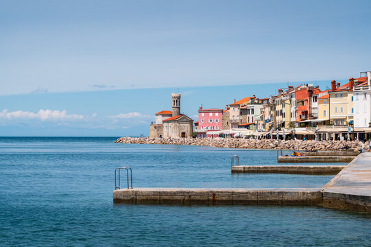 Front de mer de Piran avec le phare Piranski svetilnik au bout par une jour ensoleill&eacute;, Slov&eacute;nie