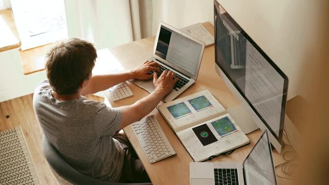 Young Man Working on Laptop and Computer Setup in Home Office Stock Video Footage