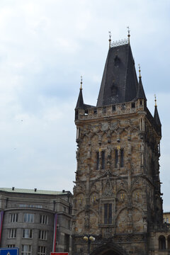 Full view of powder tower in prague with surrounding buildings for travel poster and architectural background design