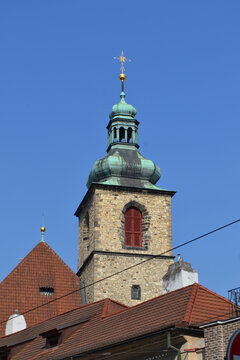 Historic prague church tower with green copper dome and red tiled roofs for travel background and architectural banner design