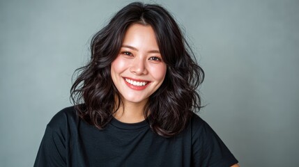 Fototapeta premium This portrait captures a cheerful woman with wavy hair, smiling broadly against a subtle background, radiating happiness, confidence, and approachability, ideal for lifestyle imagery.