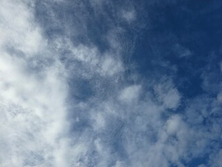 Fototapeta premium Beautiful clear blue sky with soft white clouds background on a sunny day.