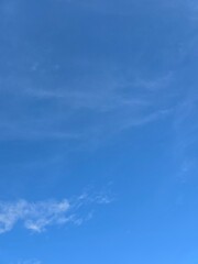Obraz premium Beautiful clear blue sky with soft white clouds background on a sunny day.