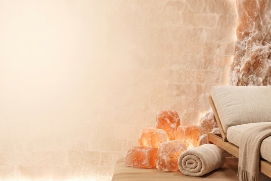 Inside a warm room during winter, salt blocks glow softly beside a wooden bench. A rolled towel rests on the table, inviting visitors to unwind and rejuvenate