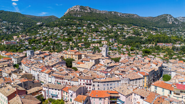 Aerial drone view of the historic old town of Vence and its terracotta rooftops overlooked by the Baou de Saint Jeannet mountain on the French Riviera