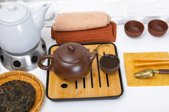 Authentic Chinese tea ceremony set with yixing clay teapot and chaban bamboo tray. Traditional puerh tea preparation on tabletop. Culture, ritual and relaxation wellness concept