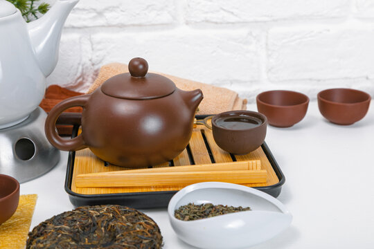 Traditional Chinese tea ceremony with yixing clay teapot and chaban bamboo tray. Authentic Asian puerh tea presentation with ceramic cups and dry leaves for ritual relaxation concept