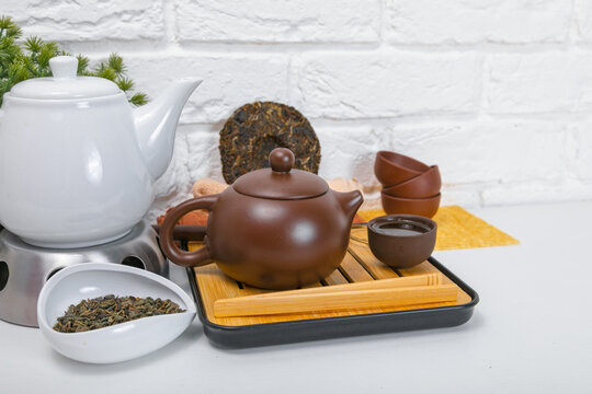 Yixing clay teapot on bamboo tea tray for traditional Chinese tea ceremony. Puerh tea preparation set. Authentic Asian tea culture ritual, drink presentation on white tabletop background