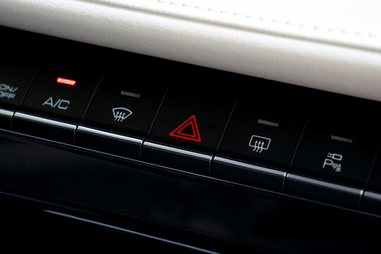 Modern Car Dashboard Control Panel with Illuminated Red Hazard Light Button and Climate Controls