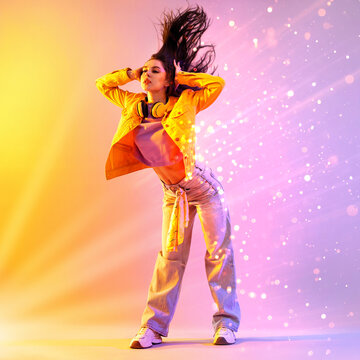 Young hip-hop dancer posing on colorful background. Bright creative poster