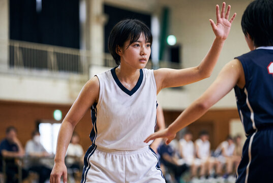 試合中、真剣な眼差しでディフェンスをする女子バスケットボール選手