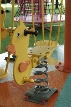 Outdoor children's playground seesaws shaped like motorcycles and toy horses.