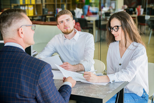 Young Couple Signing Documents with Financial Advisor in Office Meeting