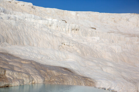 White travertine terraces and thermal pools in Pamukkale Turkey on a sunny day