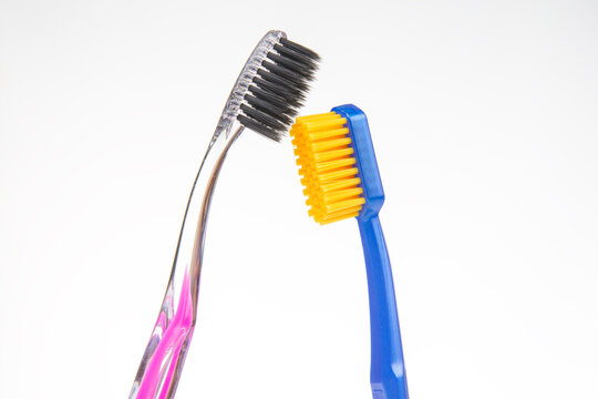 Two toothbrushes are side by side on a clean background showing different designs and bristle colors