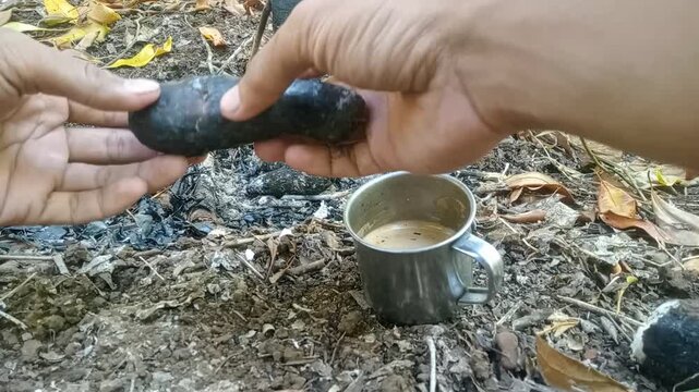 Breaking open hot steaming baked taro root with smoke close up