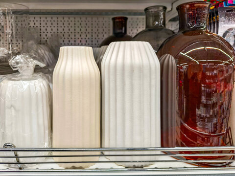Ceramic vases and glass decanter on supermarket shelf. Home decor retail display in department store. Modern interior design accessories for house organization and aesthetic decoration