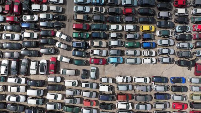 Stacked cars for used auto parts sale at an outdoor junkyard	