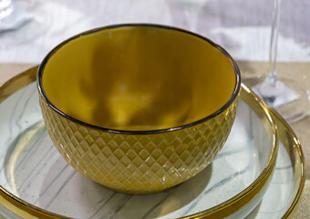 Empty gold decorative ceramic bowl on plate inside modern interior