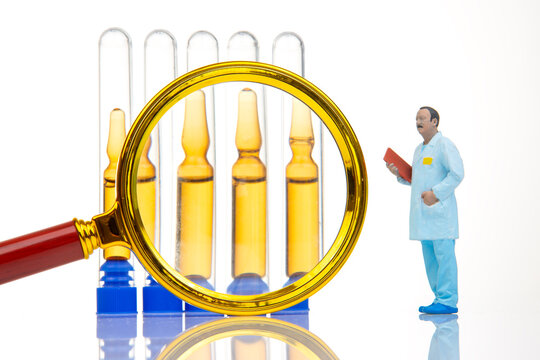 Miniature people with lab equipment in a scientific setting