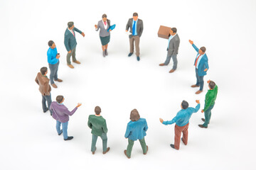 Fototapeta premium Miniature figures gather in a circle during a meeting in a simple setting