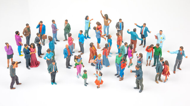 Miniature figures gather in a lively scene showing various activities and interactions in a large group setting