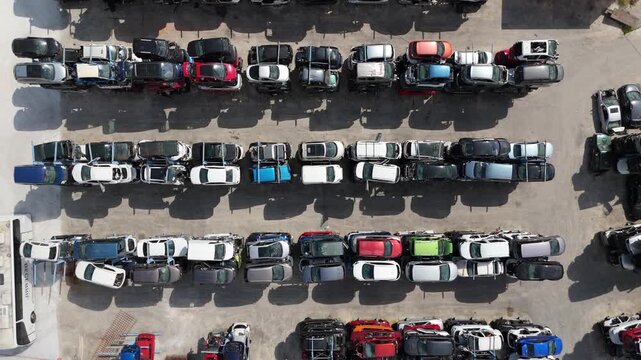 Stacked cars for used auto parts sale at an outdoor junkyard	