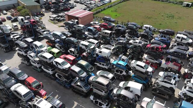 Stacked cars for used auto parts sale at an outdoor junkyard	