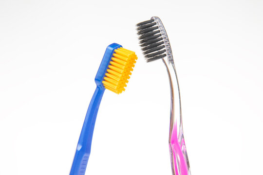 Two toothbrushes stand side by side on a white background during a simple cleaning activity