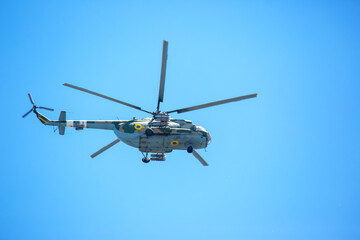 Fototapeta premium Helicopter flies in clear sky over open area during sunny day