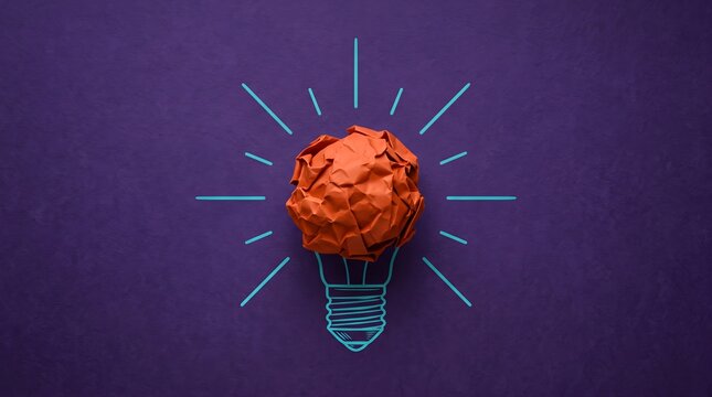 Red crumpled paper forms a bright light bulb idea.