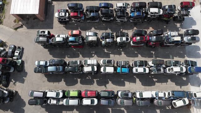 Stacked cars for used auto parts sale at an outdoor junkyard	