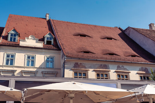 Roof eyes above cafe umbrellas on Piata Mare in Sibiu old town, Transylvania, Romania