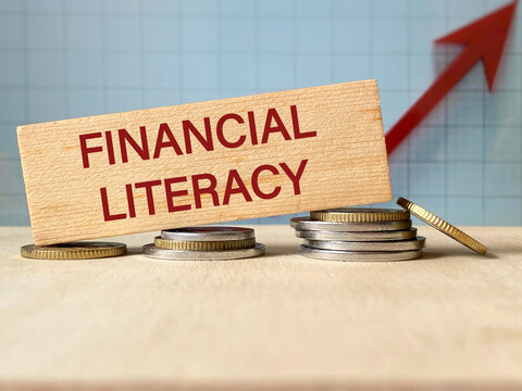 Financial Literacy Education and Personal Finance Growth Concept with wooden block on coins and an upward chart.