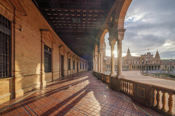 Naklejka premium Sunburst through the arched gallery at Plaza de Espana in Seville