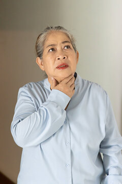 Senior, late adult old Asian female suffering from cough and sore throat, indoors scene, health care and wellness concept image