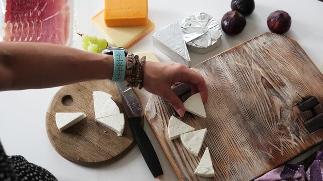 Girl Cutting Cheese On A Board For A Cheese Board And Placing Brie Cheese On A Plate