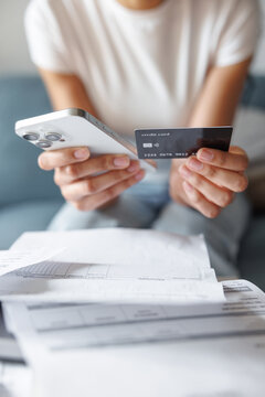 Smartphone and credit card in hands of woman paying with mobile app