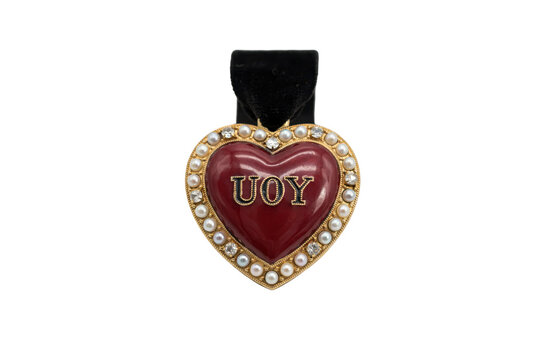 Heart shaped pendant with red enamel and pearl border featuring uoy text isolated on a transparent background