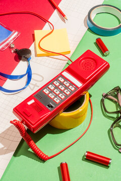 Retro red telephone with colorful office supplies