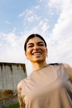 Focused fitness enthusiast in workout clothes posing in a sunlit park