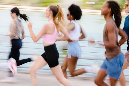 Blurry action shot of athletes running fast on a sunny morning