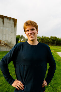 Cheerful athletic man in sportswear posing in a city park