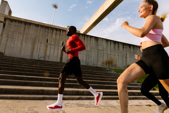 Athletic man training with a running club on a sunny morning